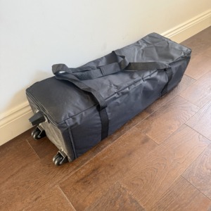 Wheeled carry bag for collapsible exhibition backdrop showing compact packed size