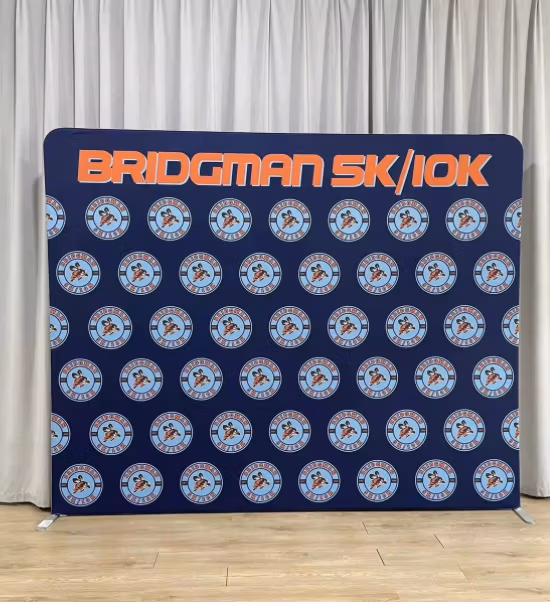Custom-printed fabric tension backdrop with vibrant branding on a straight aluminium frame.